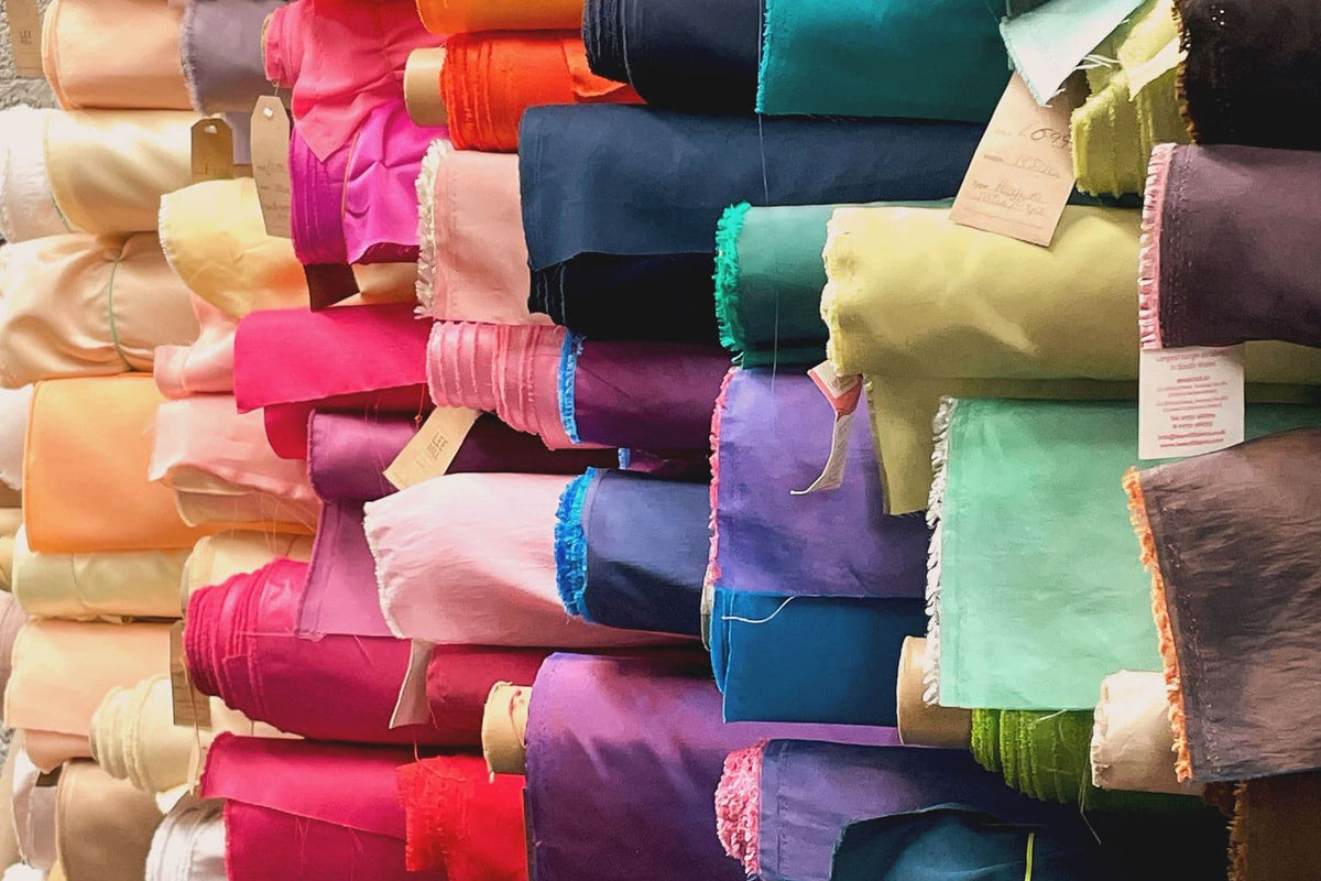 Stack of colorful fabric rolls in various colors
