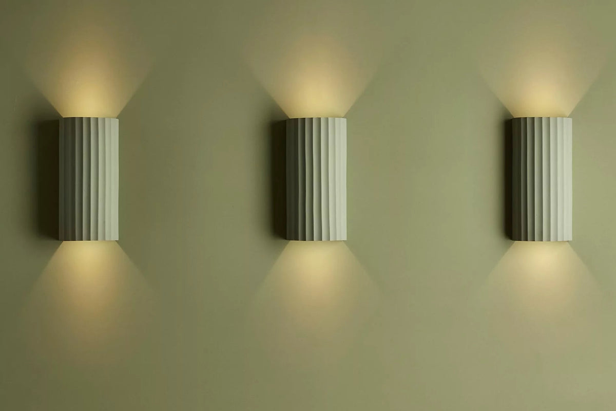 Ribbed plaster wall lights on a green background