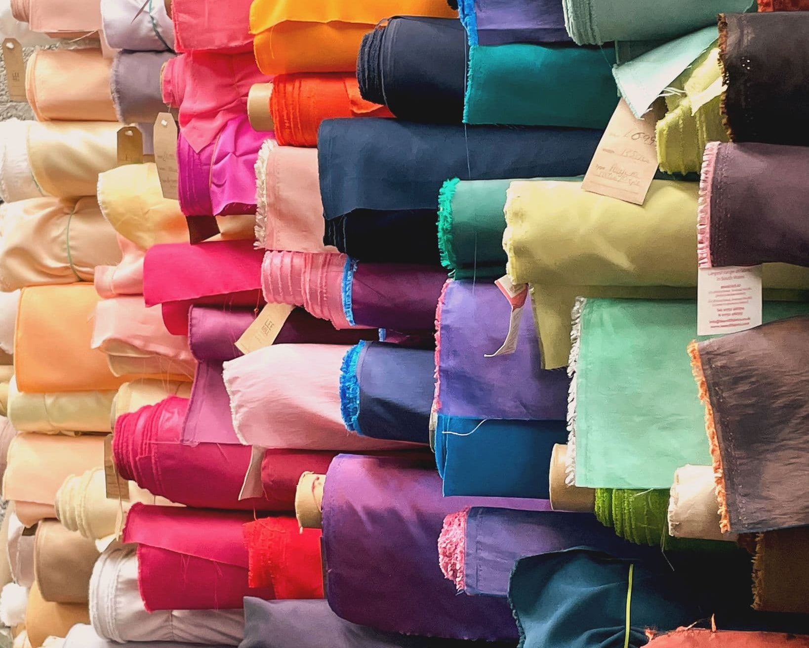 Stack of colorful fabric rolls in various colors