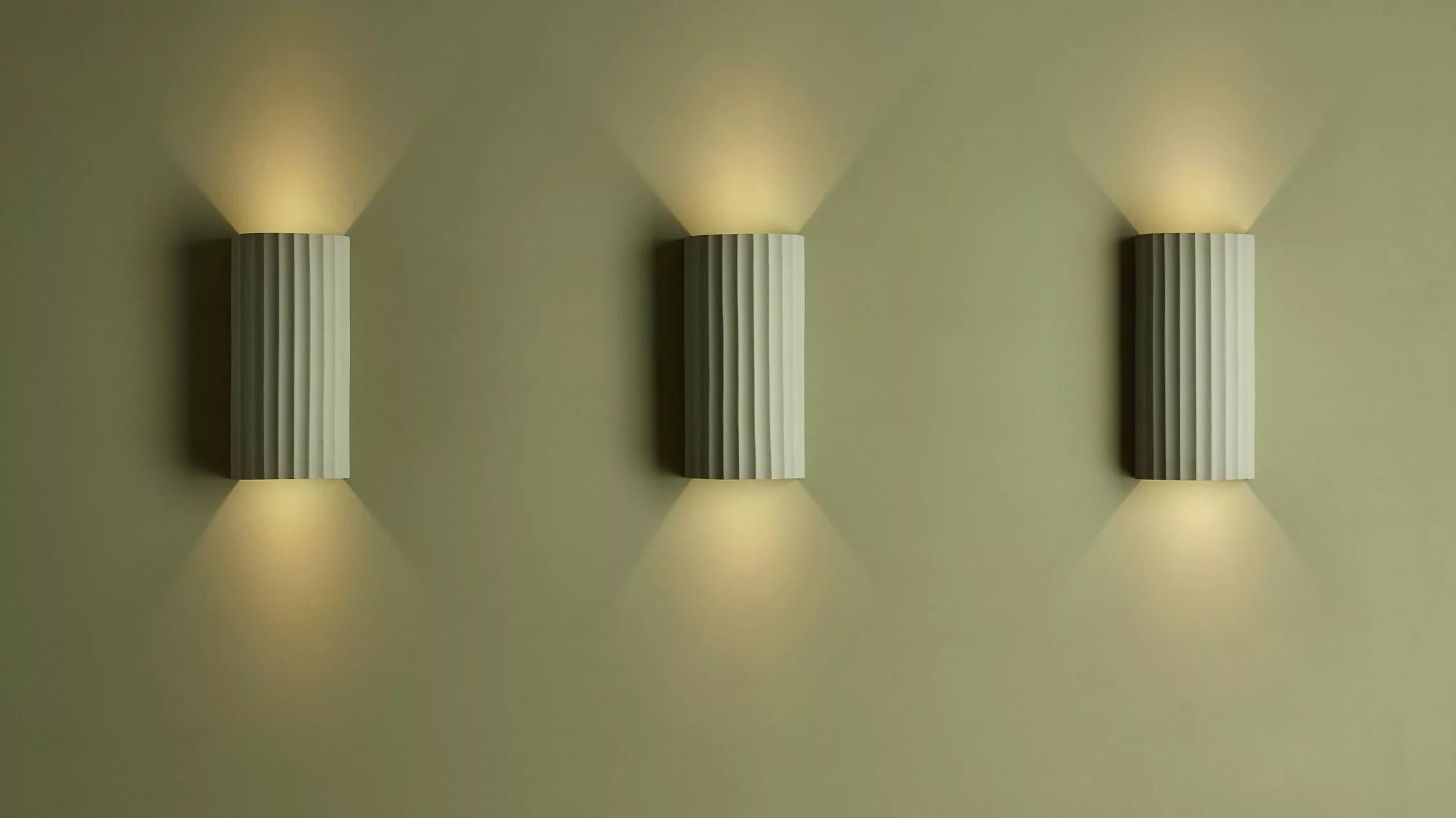 Ribbed plaster wall lights on a green background